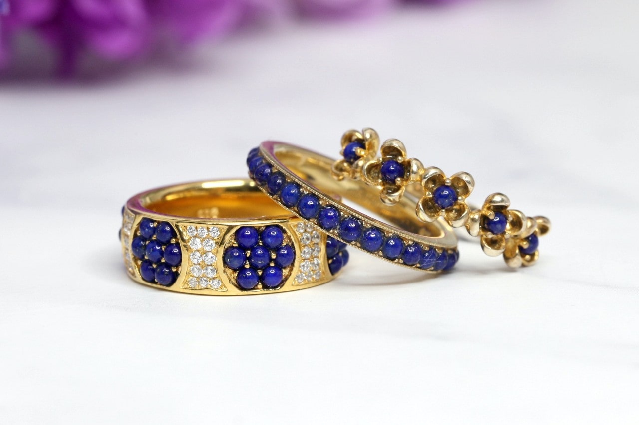 A stunning set of wedding bands and an engagement ring, featuring blue stones.