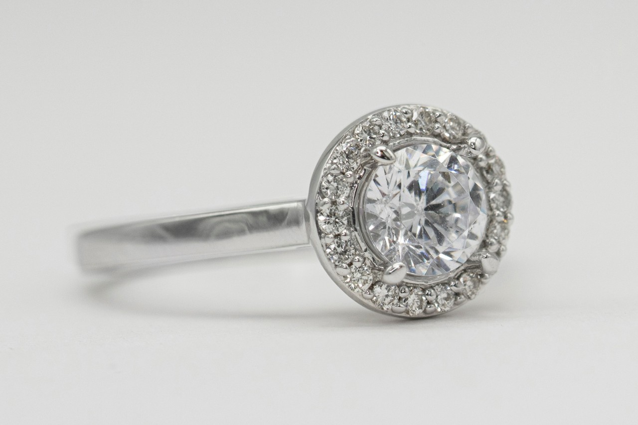 A white gold halo engagement ring with a round cut center diamond.