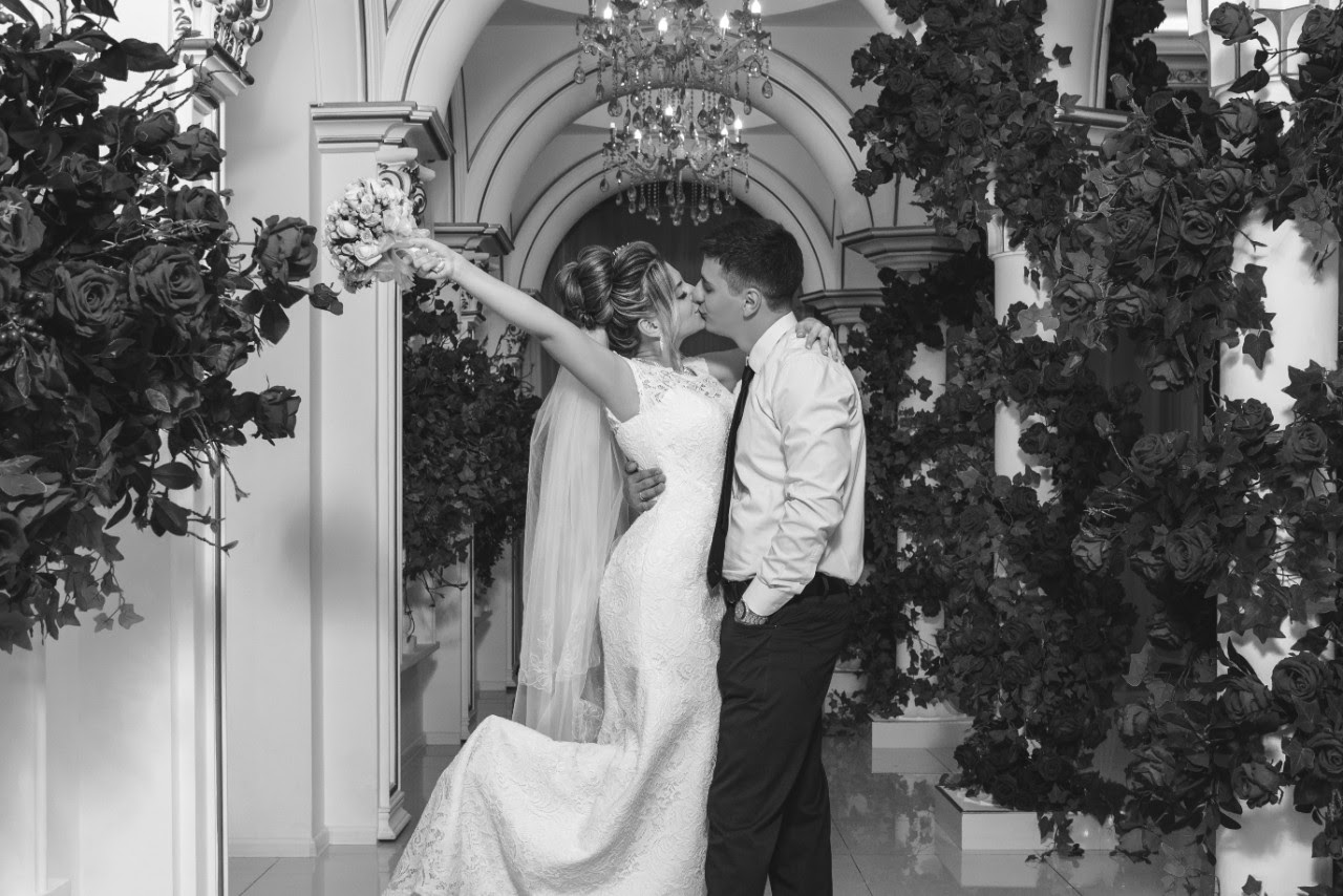 Picture of a couple kissing in front of an entry way Picture of a couple kissing in front of an entry way