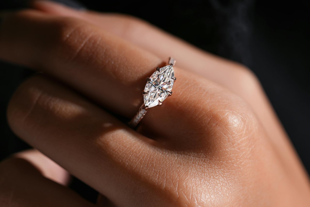 close up of woman's hand wearing solitaire engagement ring