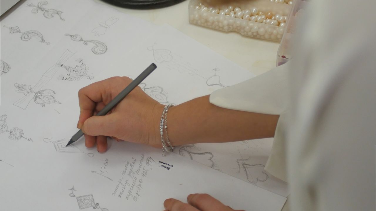 A designer drawing out jewelry designs A designer drawing out jewelry designs